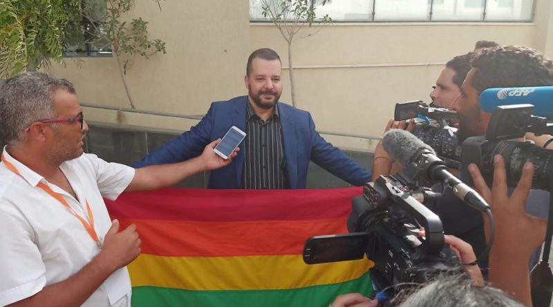 Mounir Baatour donnant une conférence de presse au siège de son parti avec la bannière LGBTQ