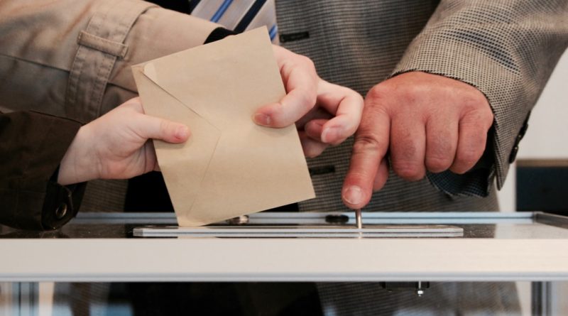 Une personne glissant son bulletin de vote dans l'urne