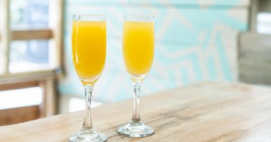 Deux verres de jus d'orang posés sur une table.