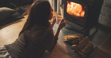 Une femme allongée devant une cheminée.