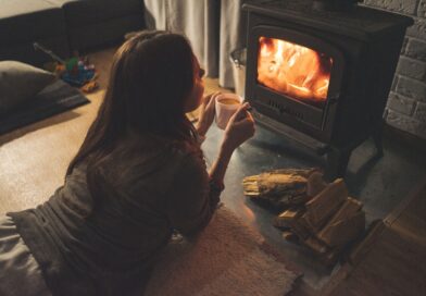 Une femme allongée devant une cheminée.